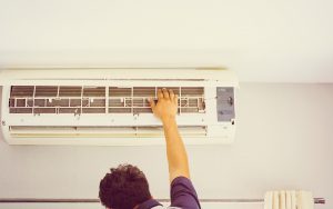 Repairman fixing air conditioning system. We have a list of common air conditioning problems and what to do about them.